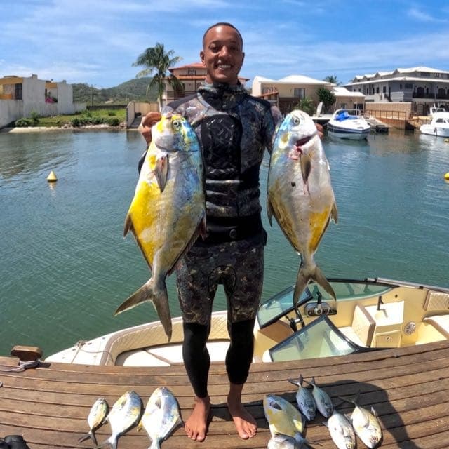 Bryan Damier segurando peixes após mergulho de pesca submarina
